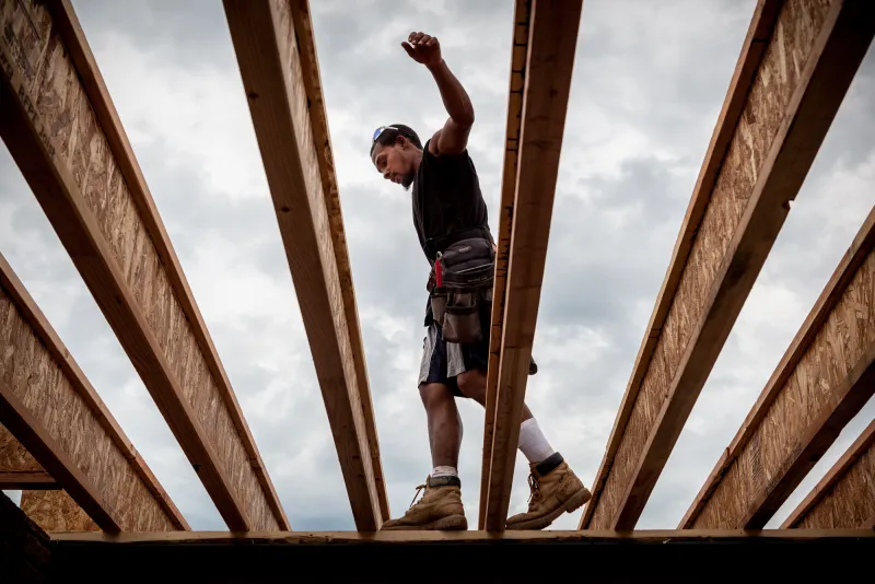 Jesse Vargas balances on a beam while working on a home on Queens Brook Way in Franksville, Wisconsin.