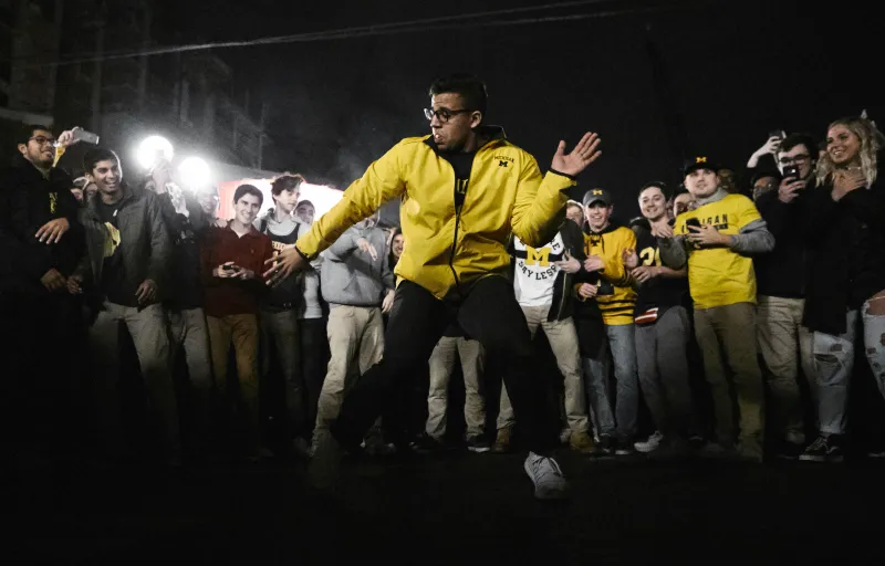 Michigan students celebrate their win against Loyola basketball by forming a circle and taking turns dancing inside at the intersection of University Ave. and Church St. in Ann Arbor on Saturday. Police shut down traffic as students flooded the streets after Michigan's victory.