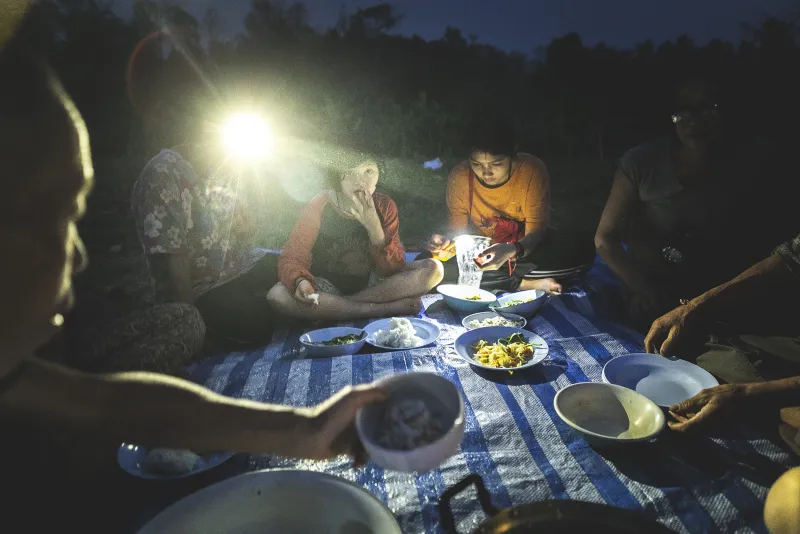 A Buddhist monk for many years, Pinan, far left, dishes out vegan food grown on his farm for his “brothers and sisters” as they begin eating on a tarp under the stars in a rural village outside Chiang Mai, Thailand “My religion is love” Pinan says “There are four rules: take care of other people, take care of animals, take care of the earth, and no attachments to anything.” he continues. No attachments, Pinan explained, includes things, people, feelings, and the past.