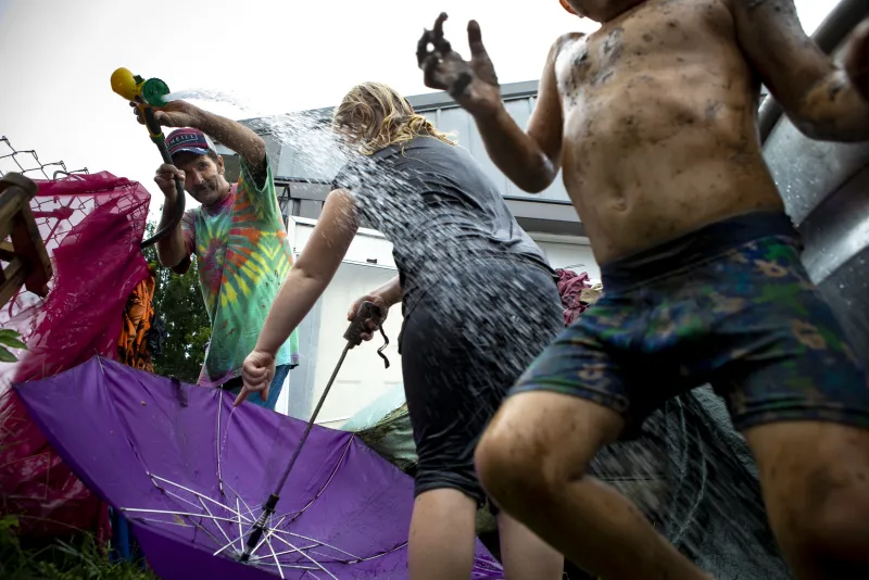 Jerry McDonald, 51, tries to wash off his grandchildren, (left to right) Abby Hutchison, 5, and SJ Hutchison, 2, after a mud fight in their front yard on Monday, September 17, 2018 in The Plains, Ohio. Neighbors helped douse a small electrical fire in the Hutchison kitchen earlier in the day, so the Hutchisons decided to grill on the porch instead of using their stove, leading to a free-for-all mud fight in the front yard with the two Hutchison children and several others neighbors’ kids. “He is a ball of energy!” Katie Hutchison said of her son, SJ.