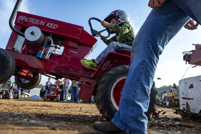 Clinton Erb, 7, pops a wheelie as he pulls back on the throttle of his mini tractor while his father walks along side him at the children’s Barlow Fair Tractor Pull in Barlow, Ohio on Saturday, Sep. 30, 2018.
