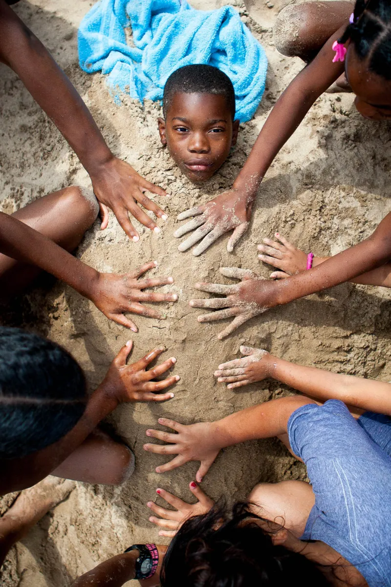 Local Racine students bury one another in the sand at North Beach Oasis in Racine, Wis. on June 22, 2017.
