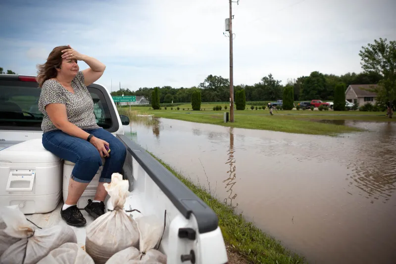 Cindy Hunt sits in a pickup truck used to transport sandbags to her son's flooded home.