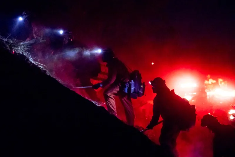 Inmate firefighters look for burning embers left over on a scorched hillside after the fire in Sunland-Tujunga, Calif. burned 13 acres on December 28, 2017.