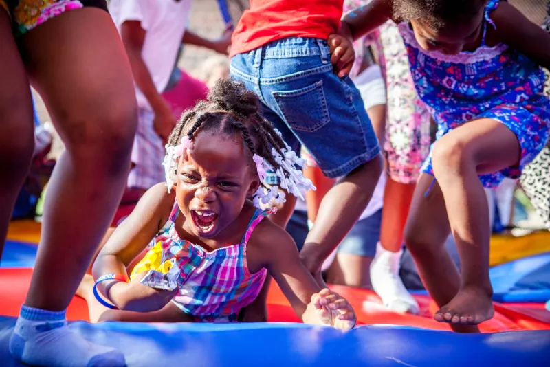Jesharia Washington is nearly trampled on a donated bounce-house during a National Night Out event at the Sunset Apartments near Racine, Wisconsin.